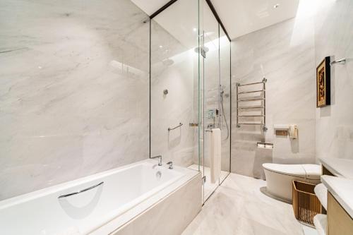 a bathroom with a tub and a glass shower at Hong Qiao State Guest House in Shanghai