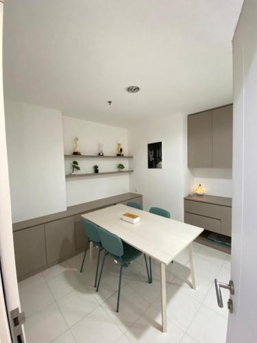 a kitchen with a white table and chairs at Win Sentul Tower Apartement in Citaringgul 1