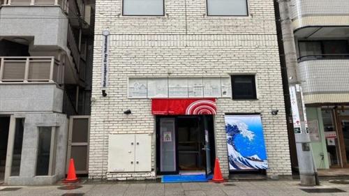 a brick building with a door with a painting on it at RetroSpect Stay Yokohama - Vacation STAY 99033v in Yokohama