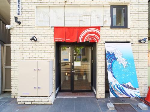 a building with two doors and a red awning at RetroSpect Stay Yokohama - Vacation STAY 03277v in Yokohama