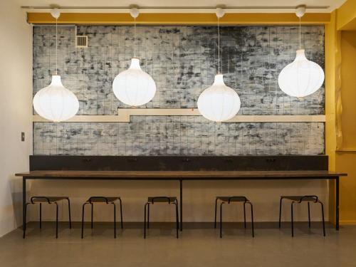 a table with four stools and three pendant lights at RetroSpect Stay Yokohama - Vacation STAY 03277v in Yokohama