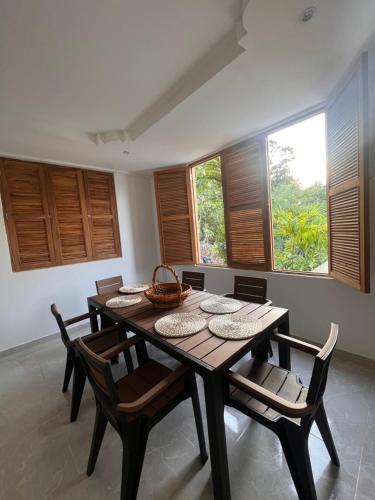 a dining room with a table and chairs and windows at LA VICTORIA Casa tropical con piscina privada in Carmen de Apicalá