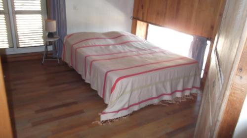 a bed with a striped blanket in a room at Le Mas De La Siffleuse in Jaujac