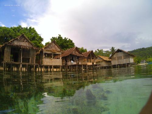 a group of houses sitting on the water at Subdikar Guest House in Sageurin
