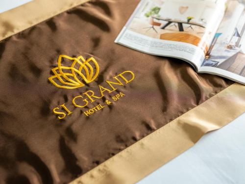 a book and a bag with a gold logo on it at Si Grand Ninh Binh Hotel in Phúc Trì