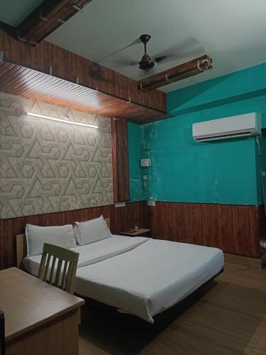a bedroom with two beds and a green wall at Hotel Pranjal Inn in Patna
