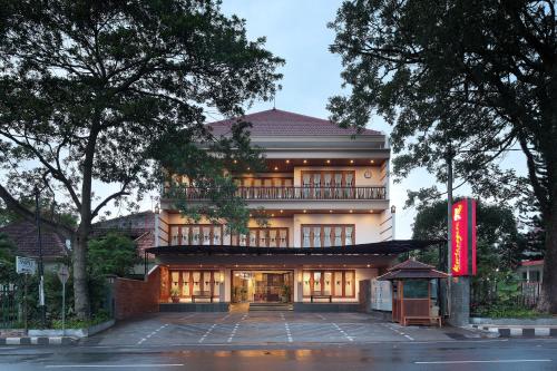 a building with a red sign in front of it at Kertanegara Premium Guest House in Malang