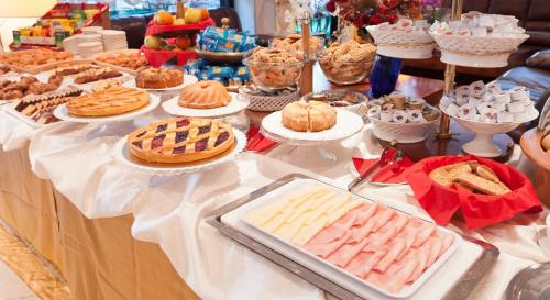 einen Tisch mit Torten, Kuchen und anderen Desserts in der Unterkunft Hotel Nadir in Milano Marittima