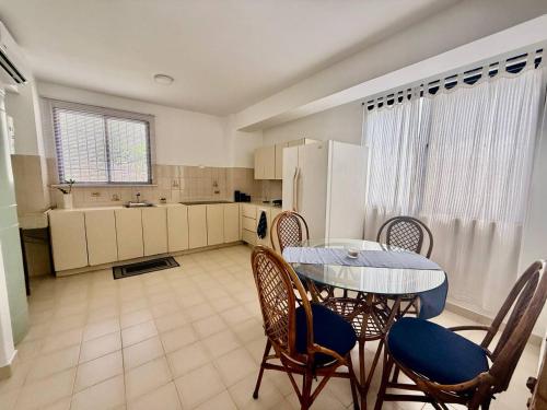 een keuken met een tafel, stoelen en een koelkast bij Apartamento frente a Bahía de Pampatar in Pampatar