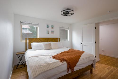 ein Schlafzimmer mit einem großen weißen Bett mit einem hölzernen Kopfteil in der Unterkunft Hot Tub + Views | Cozy Retreat in Pagosa Springs