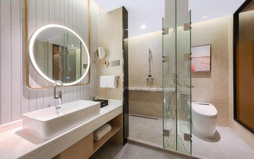 a bathroom with a sink and a glass shower at Vienna International Hotel Xi'an Jinye Road Branch in Xi'an