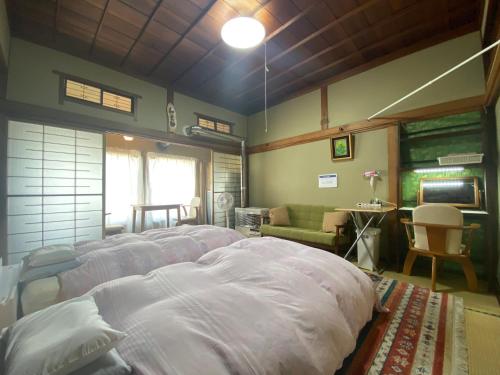 a bedroom with a large white bed in a room at Ryokan Sansui in Furano