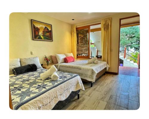 a bedroom with two beds and a window at Alojamiento el Abuelo in San Pedro La Laguna