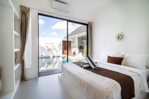 a hotel room with a bed and a large window at Villa Casa More by BaliSuperHost in Ungasan