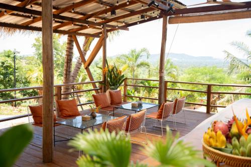 a patio with two tables and chairs on a deck at Amaya Kampot Homestays in Kampot