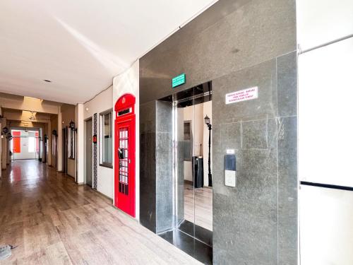 a red phone booth in a hallway in a building at Sans Vibes Hotel Syariah Graha 100 Gubeng Surabaya in Surabaya