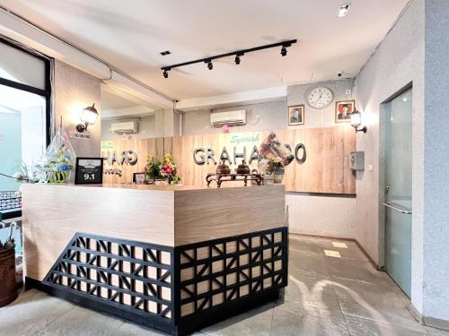 a bar in a restaurant with a clock on the wall at Sans Vibes Hotel Syariah Graha 100 Gubeng Surabaya in Surabaya