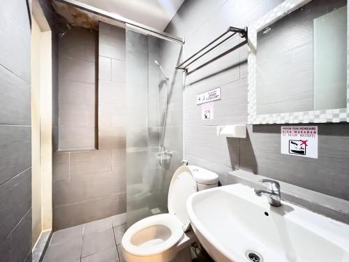 a bathroom with a toilet and a sink at Sans Vibes Hotel Syariah Graha 100 Gubeng Surabaya in Surabaya