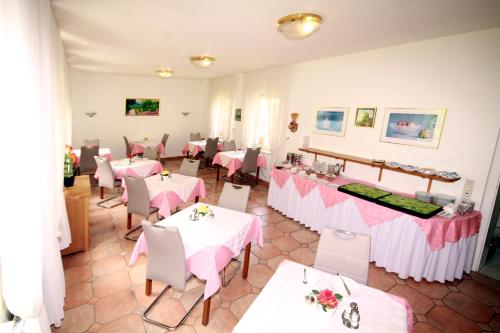 バート・ハルツブルクにあるVilla Feiseのピンクのテーブルクロスが敷かれたテーブルと椅子が備わるレストラン