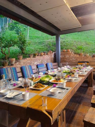 a long wooden table with plates of food on it at Dai House in Xishuangbanna Village in Menghan