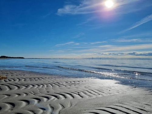 a sandy beach with the ocean on a sunny day at 6 person holiday home in Slagelse in Slagelse