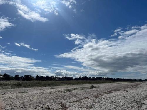 a dirt road in a field with a cloudy sky at 6 person holiday home in Slagelse in Slagelse