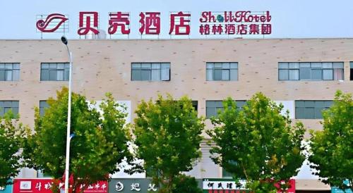 a building with a sign on top of it at Shell Hotel Wuhu Jiujiang District Daqiao Town Huashan Road in Wuhu