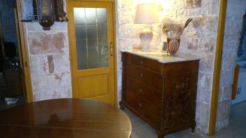 a room with a wooden dresser with a lamp on it at Masseria Donna Licia in Pezze di Greco