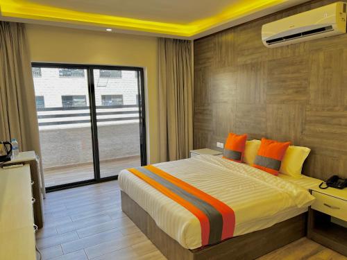 a bedroom with a large bed with orange pillows at Sky Hotel in Aqaba