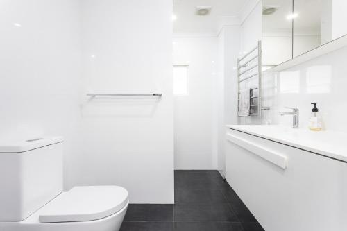 BundeenaにあるDiscover Lambeth Walk Beach Homeのトイレと洗面台を備えた白いバスルーム