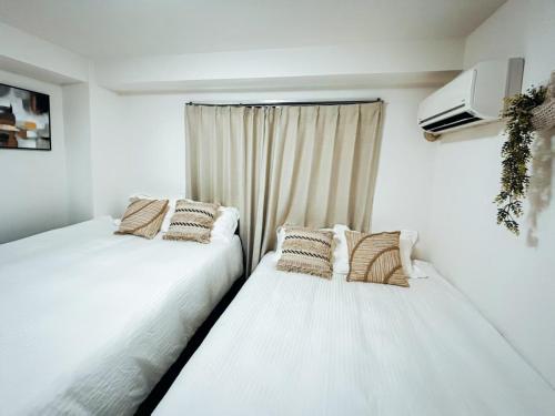 two beds sitting next to a window in a room at sakura 401 in Tokyo