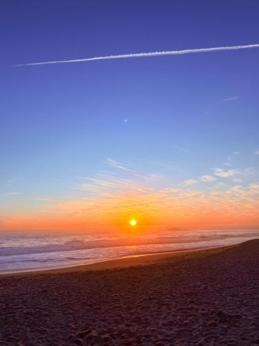 a sunset on the beach with an airplane flying in the sky at Alójate con esta hermosa vista in Concón
