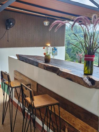 a bar with two chairs and a counter with a window at Phahee valley ผาฮี้วัลเล่ย์ in Ban Ko Doi Tung
