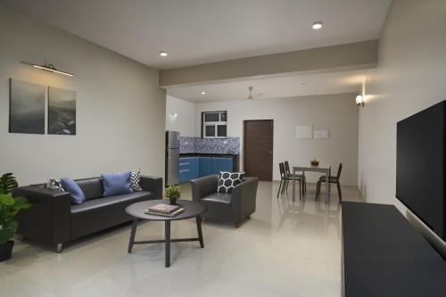 a living room with a couch and a table at Paprika Stays Panjim Donapaula in Panaji