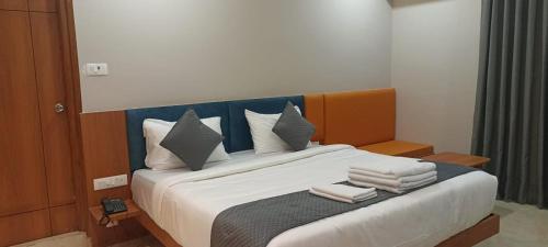 a bedroom with a large bed with towels on it at Vasatee Kondapur in Kondapur