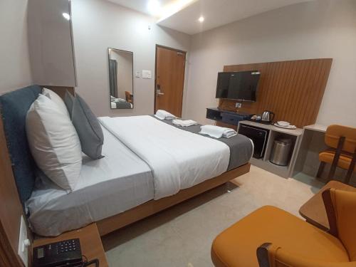 a hotel room with a large bed and a television at Vasatee Kondapur in Kondapur