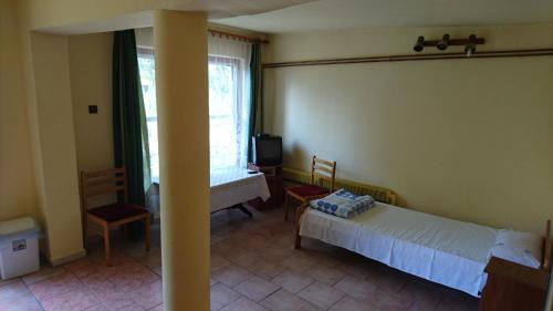 a bedroom with two beds and a table and a window at Ośrodek Wypoczynkowy Duet in Zamość