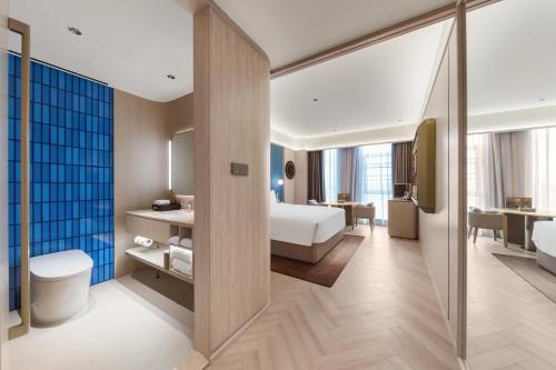 una camera d'albergo con una camera da letto e un bagno di 上海浦东机场祝桥桔子水晶酒店 a Shanghai