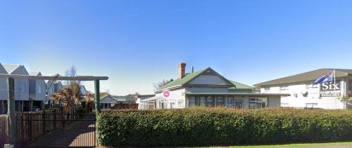a white house with a fence in front of it at Rotorua Hostel in Rotorua