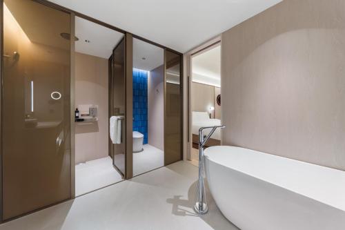 bagno con ampia vasca e servizi igienici di 上海浦东机场祝桥桔子水晶酒店 a Shanghai
