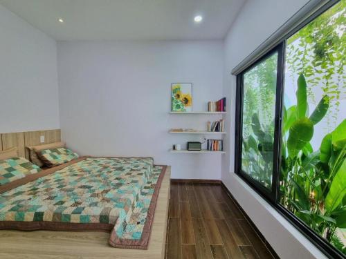 una camera da letto con un letto e una grande finestra di Nha Trong Pho - The Chilling House a Buôn Ma Thuột