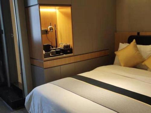a hotel room with a bed with a mirror at City Comfort Inn Hotel Wuhan Optics Valley Square Metro Station Zhongnan Minzu University in Wuhan