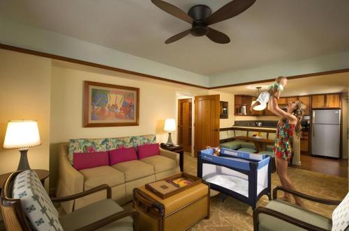a woman holding a child in a living room at Aulani, Disney Vacation Club Villas in Kapolei