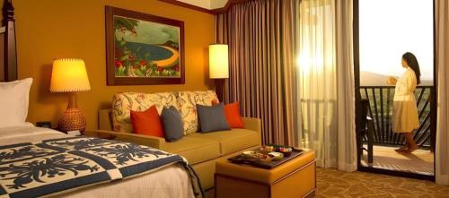 a hotel room with a bed and a couch at Aulani, Disney Vacation Club Villas in Kapolei