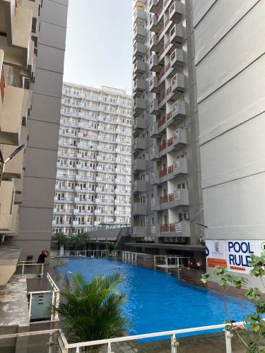 a large apartment building with a large blue swimming pool at Win Sentul Tower Apartement in Citaringgul 1