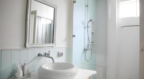 a white bathroom with a sink and a mirror at Baan Hmon-Oon in Chiang Mai