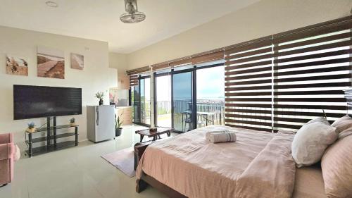 a bedroom with a large bed and a large window at Eagles Nest Beach Resort Room 6 in Samal