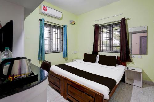 a bedroom with a bed and a tv in a room at Super Townhouse Balaji Dental College Pallikarani Formerly Orchid Sankrish in Chennai