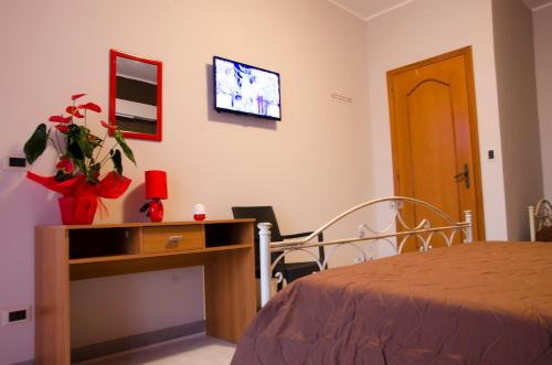 a room with a bed and a desk and a tv at Sicily House in Mazara del Vallo