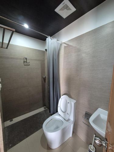 a bathroom with a toilet and a shower and a sink at Eagles Nest Beach Resort Room 6 in Samal